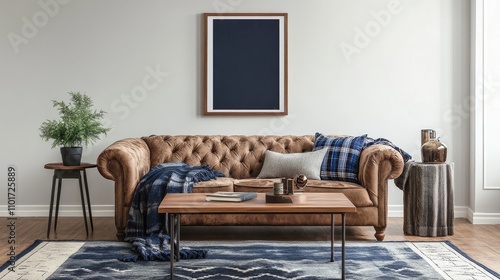 A brown leather chesterfield sofa sits in a living room with a dark blue framed picture above it. The sofa is styled with a throw and pillows, creating a cozy and sophisticated atmosphere.