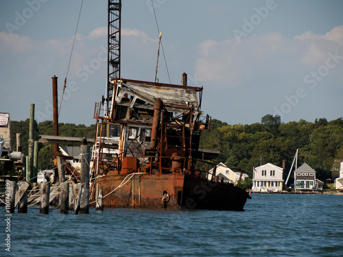 old abandoned rusted ship in harbor port of greenport long island new york photo