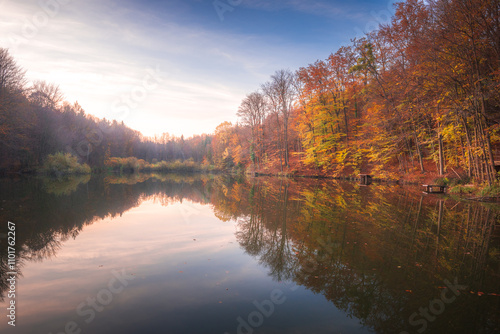 Autumn colorful foliage over lake with beautiful woods in red and yellow color. Bakony Forest and Mountain, Pisztrangos Lake, Hungary