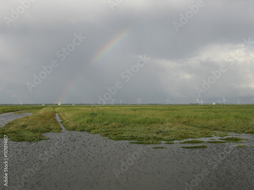 Regen, Wolken und Regenbogen über Wattenmeer und Salzwiesen an der Nordseeküste photo