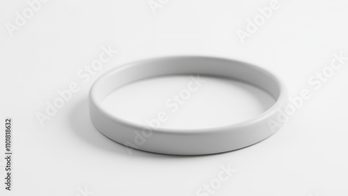 Obraz na płótnie A single silicone bracelet with a polished surface lies flat on a plain white background, ready for custom designs. w salonie