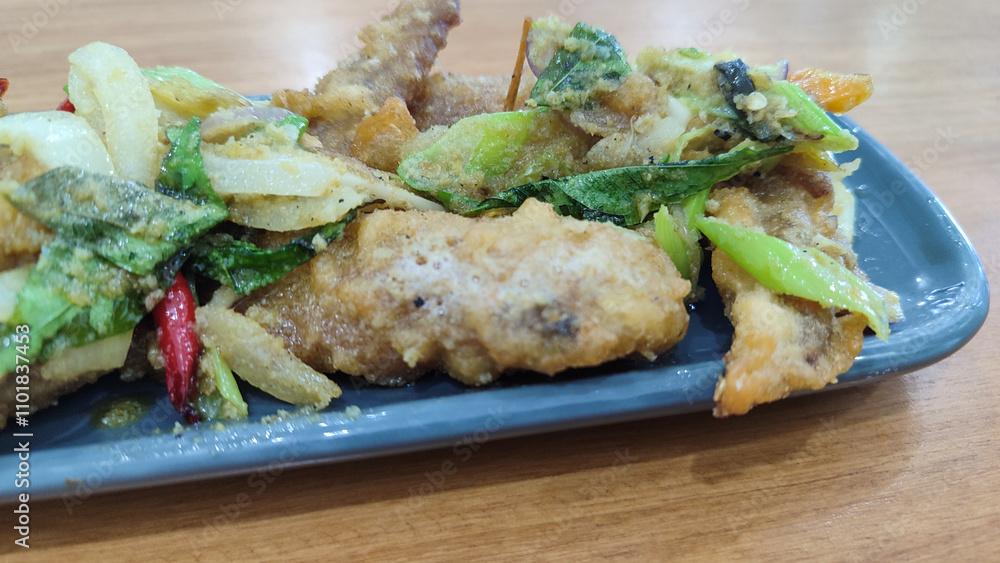 Fried chicken with salted egg in blue ceramic plate isolated with white. Selective focus. Fried chicken with salted egg in blue ceramic plate isolated with white. Selective focus.