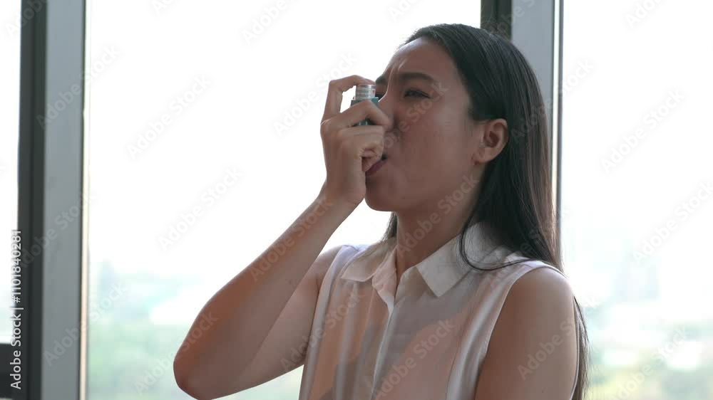 A woman is seen using an inhaler to manage her asthma symptoms. This moment highlights the importance of asthma management and the daily challenges faced by individuals with respiratory conditions.