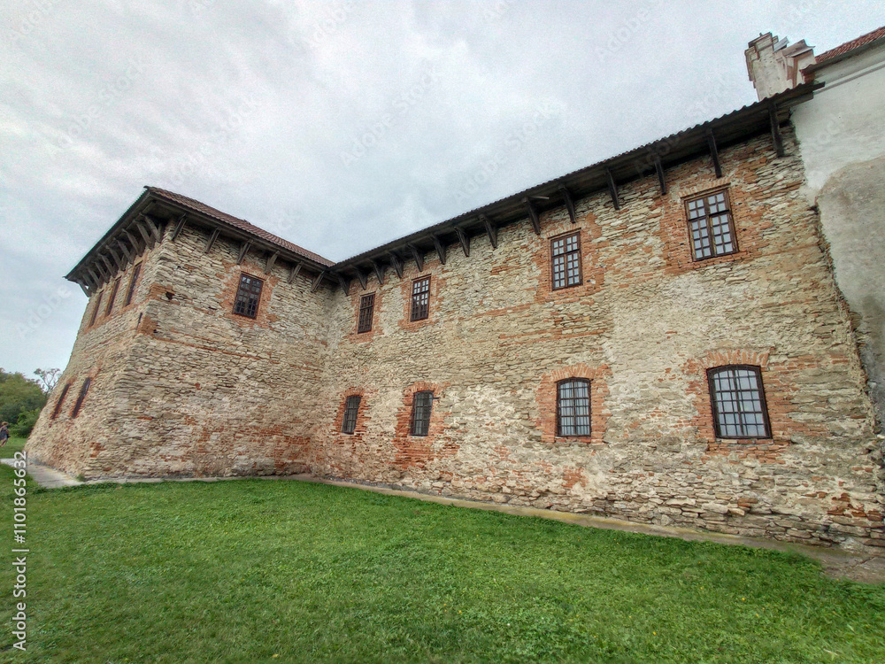 A large stone building with a green lawn in front of it A large stone building with a green lawn in front of it