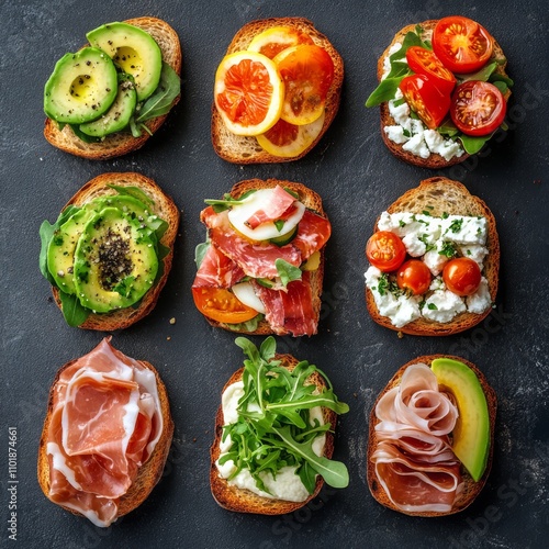 Assorted bruschetta with fresh toppings on toasted bread arranged on a dark s...
