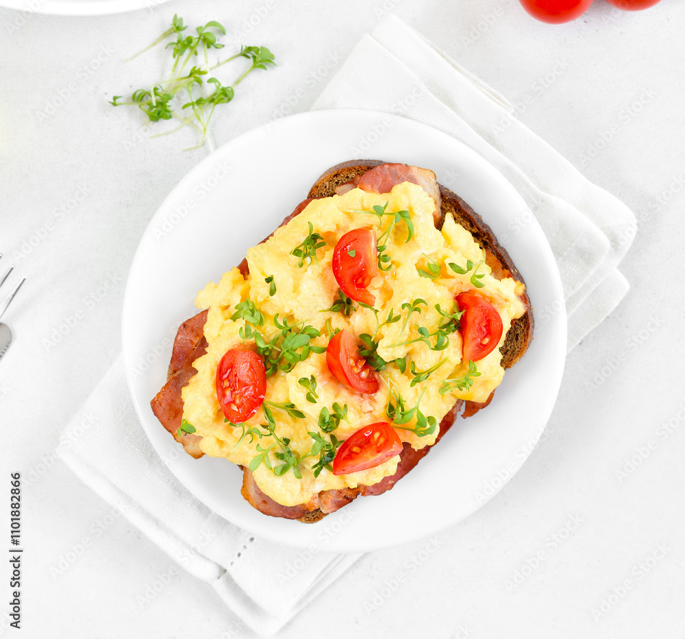Scrambled eggs with microgreen, bacon and tomatoes on bread Scrambled eggs with microgreen, bacon and tomatoes on bread