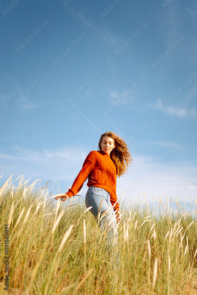 Happy woman enjoying nature outdoors in tall grass. Flying hairs. Outdoor. Fashion style. Happy woman enjoying nature outdoors in tall grass. Flying hairs. Outdoor. Fashion style.