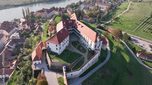 Aerial video with beautiful Ptuj castle on a hilltop above houses of Ptuj old town along Drava river in Slovenia