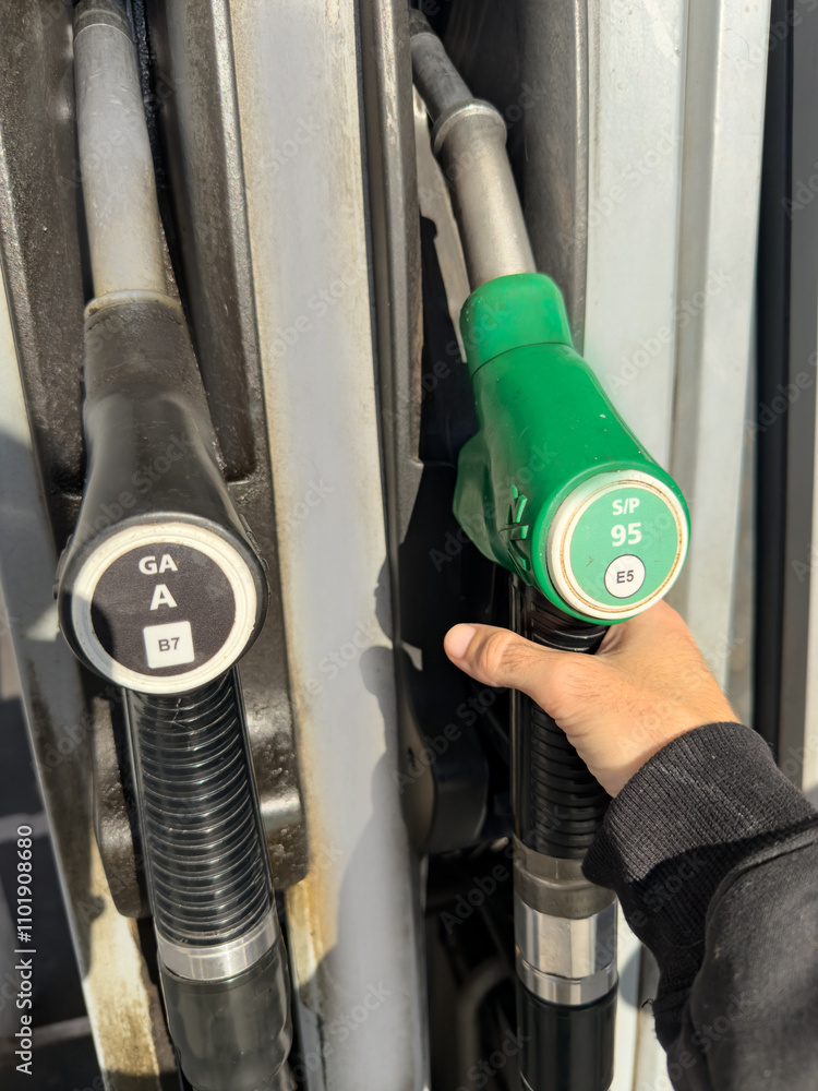 A person is filling up their car with gas at a gas station A person is filling up their car with gas at a gas station