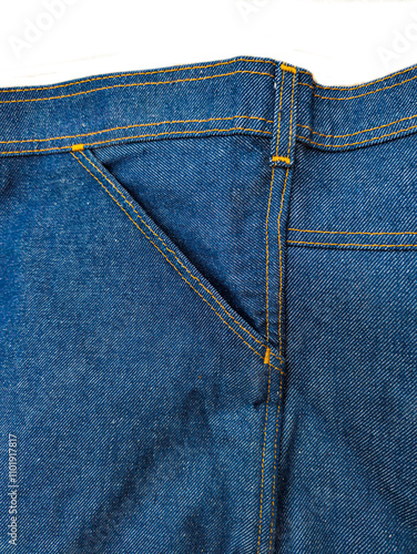 A fragment of denim clothing with a dark blue pocket.