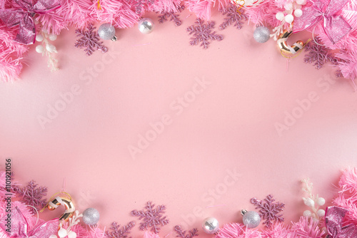 Kitschmas Christmas background with fluffy pink artificial Christmas tree brunches, pink festive bow and decorations in trendy embracing kitsch style, top view flat lay copy space photo