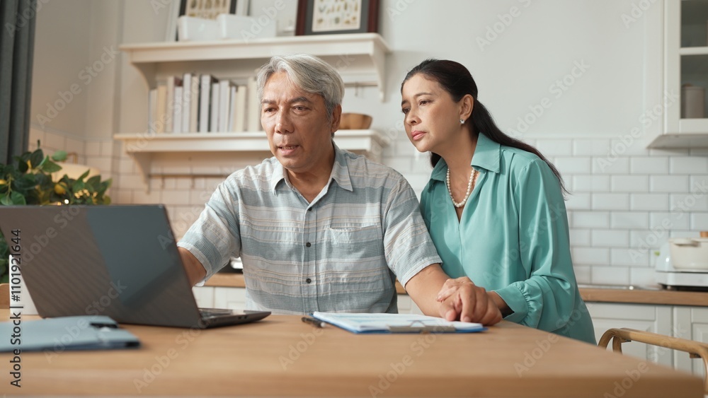 Grandmother comforting and supporting grandfather while looking at laptop show successful project and getting promotion. Happy senior businessman receive good news and talking to his wife. Myrmidon. Grandmother comforting and supporting grandfather while looking at laptop show successful project and getting promotion. Happy senior businessman receive good news and talking to his wife. Myrmidon.