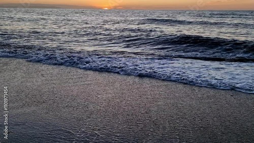 Evening sea shore. It's a quiet night, ocean waves crashing on a sandy beach. The sea waves break in close-up on a sandy beach on a summer morning. slow motion. Without people