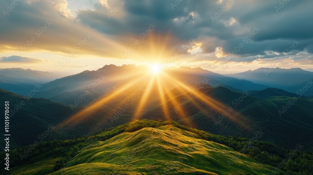 Fototapeta premium Stunning mountainous landscape with glowing golden sunlight rays streaming through the dramatic cloudy sky casting a warm glow over the serene and picturesque wilderness below