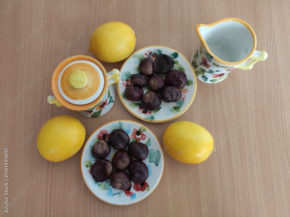 Yellow lemons and shiny brown chestnuts on the table Yellow lemons and shiny brown chestnuts on the table