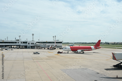 Airport Runway and Terminal Activity, A view of the airport terminal showcasing parked aircraft, ground vehicles, and jet bridges, highlighting the operations and logistics of air travel photo