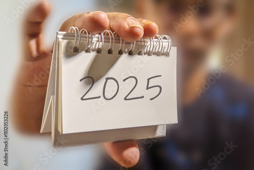 A man is showing the 2025 calendar in his hand. 2025 New Year concept photo