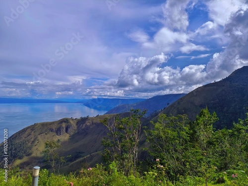 Pemandangan indah di pinggir danau toba dengan awan yang sedang menutupi matahari photo