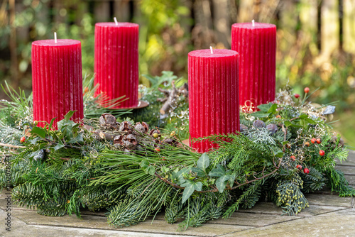 Adventskranz mit roten Kerzen und Naturmaterial