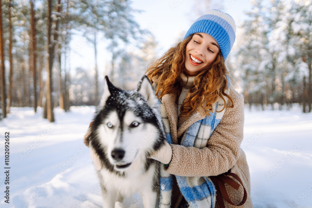 Woman laughing and playing with pet in the winter park. Husky dog. Domestic dog concept. Friendship. Woman laughing and playing with pet in the winter park. Husky dog. Domestic dog concept. Friendship.