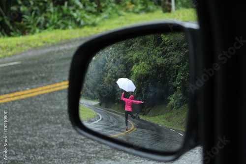 mulher caminhando em estrada com guarda-chuva - vista a partir de retrovisor, na estrada da graciosa, paraná 