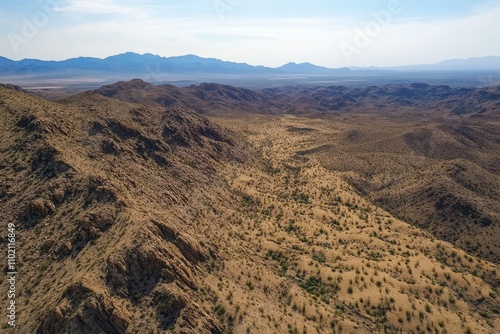 Aerial View of Rugged Desert Landscape - Stunning aerial shot of a vast desert landscape, showcasing rugged terrain, mountains, and sparse vegetation. Evokes adventure, exploration, vastness, solitud