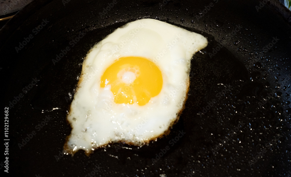 Fried egg in a frying pan. Cooking scrambled eggs. Fried egg in a frying pan. Cooking scrambled eggs.