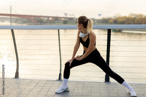A woman stretches by the ri...