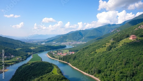 Panoramic view of a river winding through lush green mountains and valley.