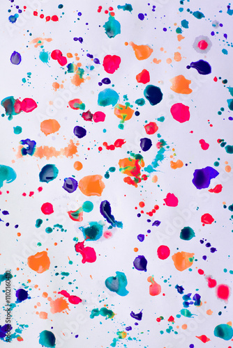 Drops of paints of different colors, on a white sheet of paper, artist's studio. Background for your creative design or addition to illustrations.