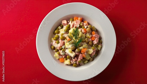 Olivier salade in a plate on a red background