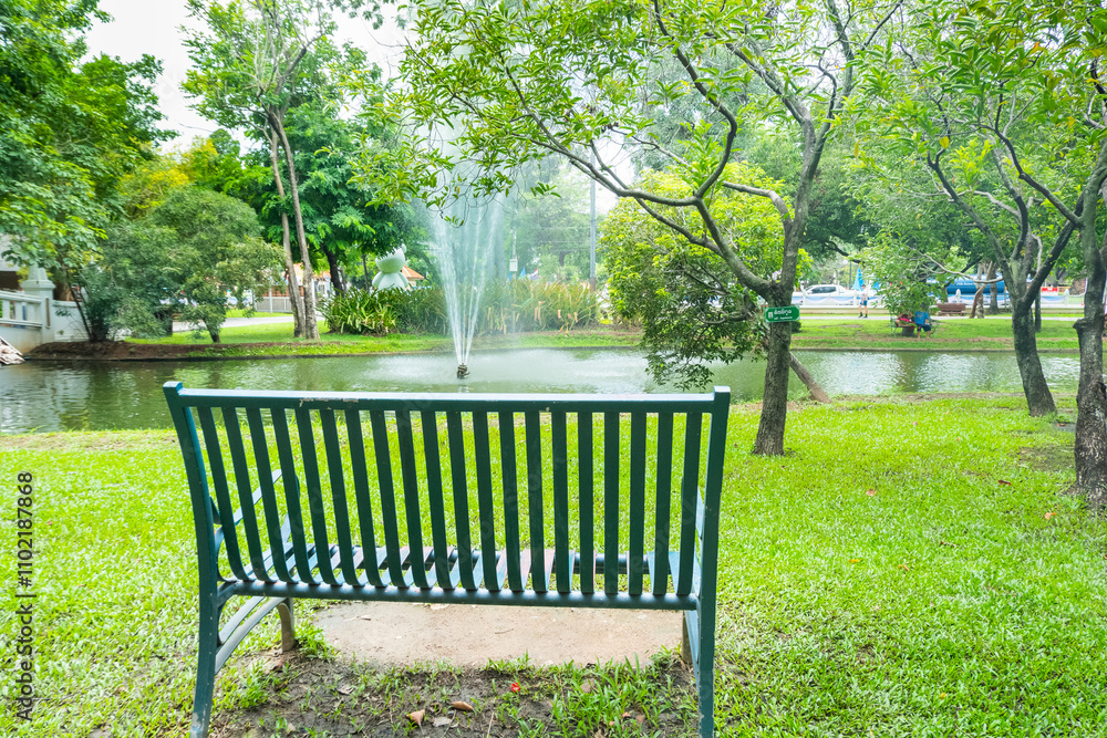 Modern bench in a public Park with view of fountain in the water pond public park,lake during spring,Beautiful green garden and Big tree,reflection in the lake in the morning,Resting in Park.. Modern bench in a public Park with view of fountain in the water pond public park,lake during spring,Beautiful green garden and Big tree,reflection in the lake in the morning,Resting in Park..