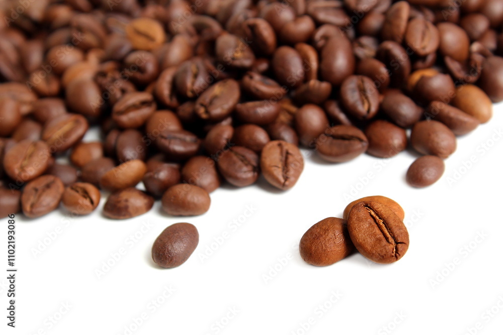 Fototapeta premium Scattered coffee beans lie on a white background.
