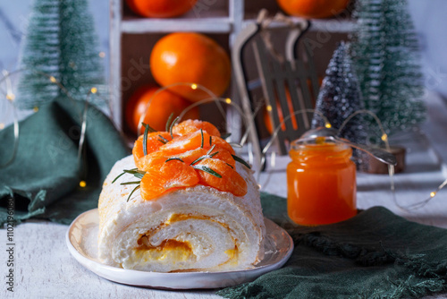 Meringue roll filled with mascarpone, cream and tangerine jam, decorative Christmas trees and tangerines.