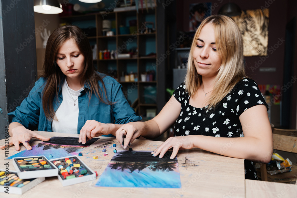 Two women creating pastel artwork together in a cozy studio setting Two women creating pastel artwork together in a cozy studio setting