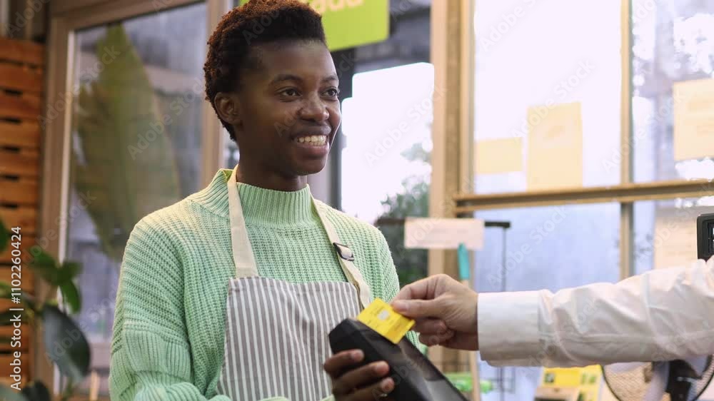 Cashier Joyfully Assists Customer with Credit Card Payment