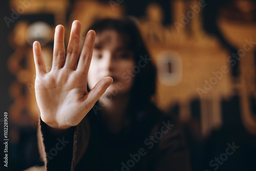 Woman Expressing Stop Gesture with Open Hand Focused in Foreground photo