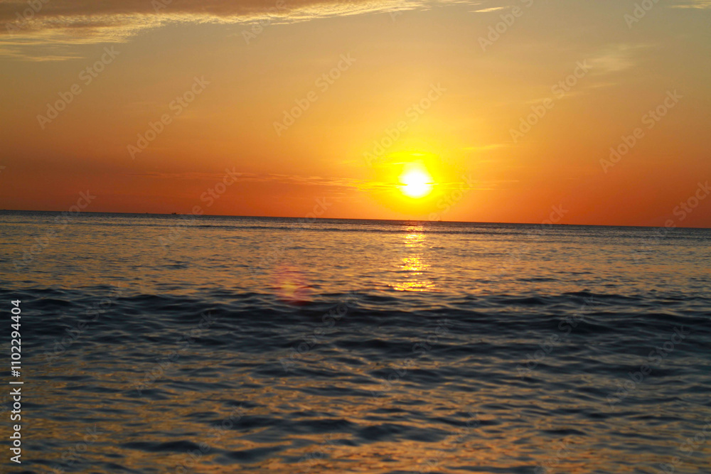 Ein atemberaubender Sonnenuntergang am Meer, bei dem die orangefarbene Sonne den Himmel und das Wasser in warme Töne taucht. Perfekt für Themen wie Entspannung, Natur oder Reisen Ein atemberaubender Sonnenuntergang am Meer, bei dem die orangefarbene Sonne den Himmel und das Wasser in warme Töne taucht. Perfekt für Themen wie Entspannung, Natur oder Reisen