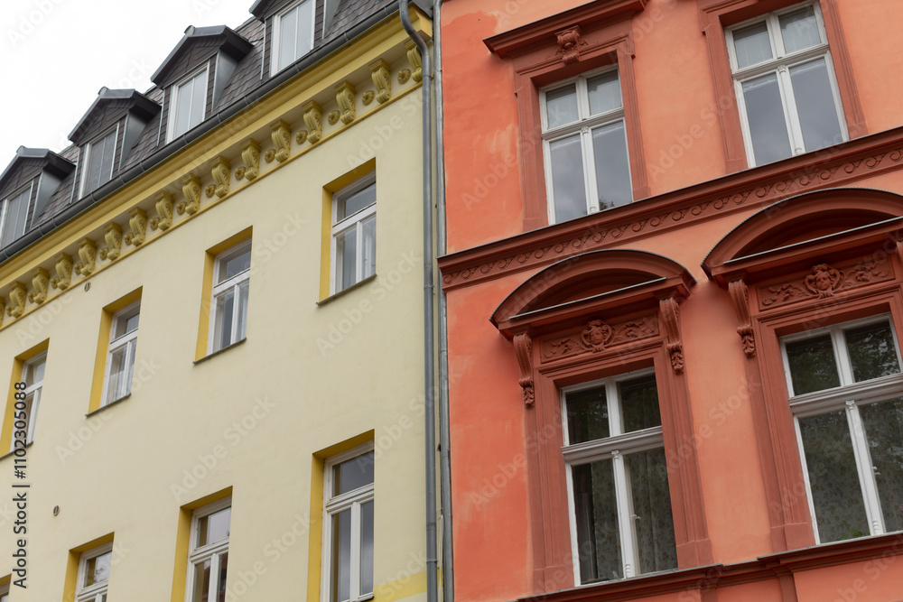 A bright yellow building and a vivid red building are situated right next to each other, creating an interesting visual contrast A bright yellow building and a vivid red building are situated right next to each other, creating an interesting visual contrast