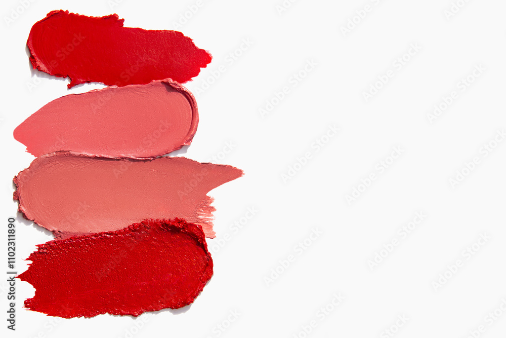 Lipstick strokes in red shades with empty space on a light white background. Cosmetic texture of matte lipstick smear. Lipstick strokes in red shades with empty space on a light white background. Cosmetic texture of matte lipstick smear.