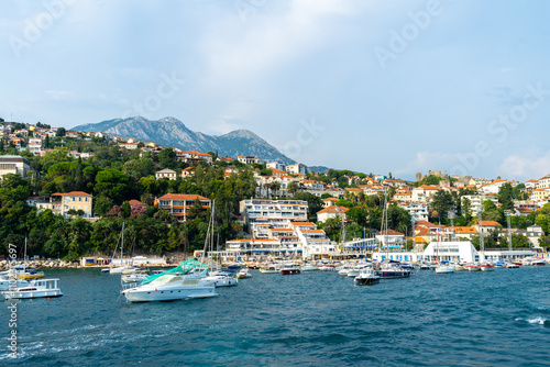 View of Herceg Novi, Montenegro. Yachts and pleasure boats on pier in Balkans, Adriatic Sea. City on side of a mountain photo