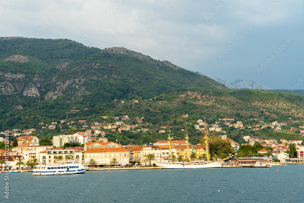 Embankment of city of Tivat, Montenegro. Sailing ship, yacht, houses, streets and mountains Embankment of city of Tivat, Montenegro. Sailing ship, yacht, houses, streets and mountains