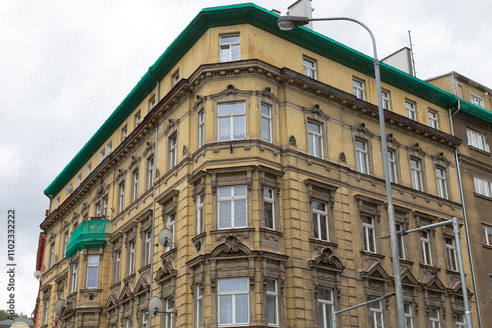 Fototapeta premium There is a large, impressive building characterized by its distinct green roof, and in front of it stands a tall street light illuminating the area