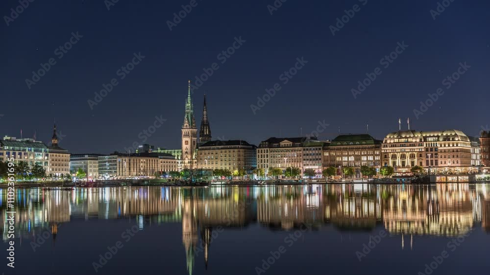 Night timelapse of Binnenalster in Hamburg, Germany, with City Hall and Nikolai Church. Illuminated historic buildings reflected in Inner Alster lake waters under a starry sky. Scenic urban landscape Night timelapse of Binnenalster in Hamburg, Germany, with City Hall and Nikolai Church. Illuminated historic buildings reflected in Inner Alster lake waters under a starry sky. Scenic urban landscape