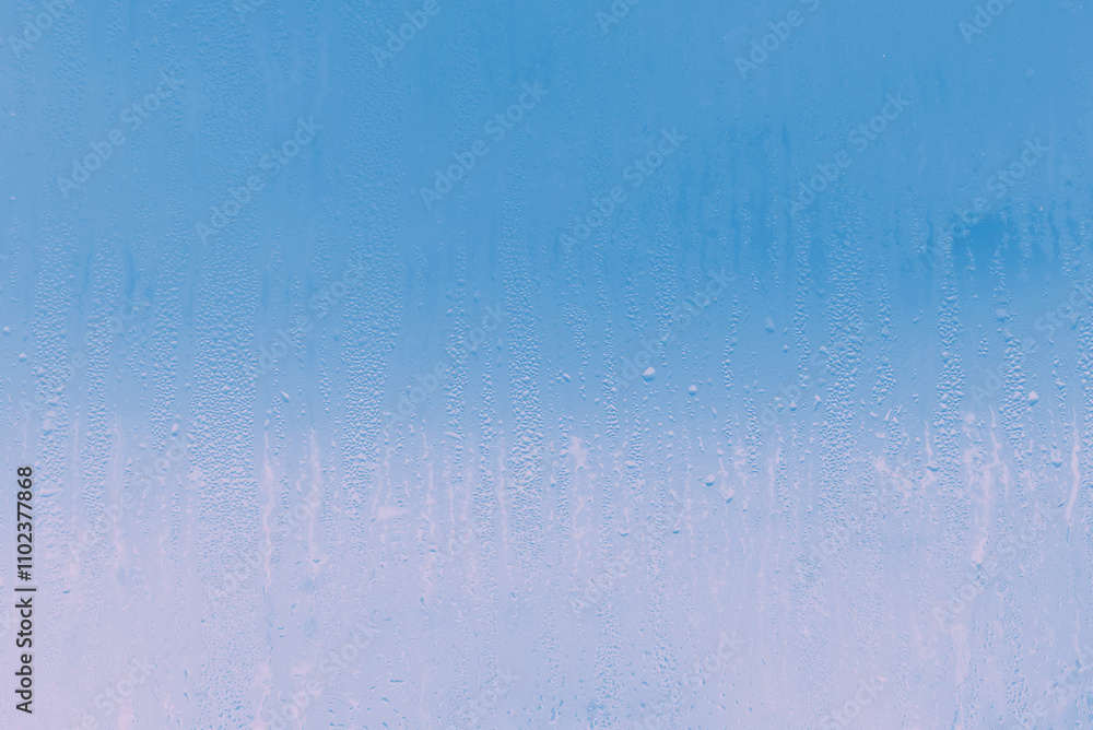 Through the glass fogged with water droplets, the blue sky and pink dawn are visible Through the glass fogged with water droplets, the blue sky and pink dawn are visible
