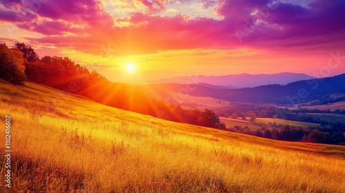 Dramatic sunset over a golden hillside with mountains in the background.