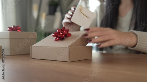 woman open gift and read greeting card for Christmas at home