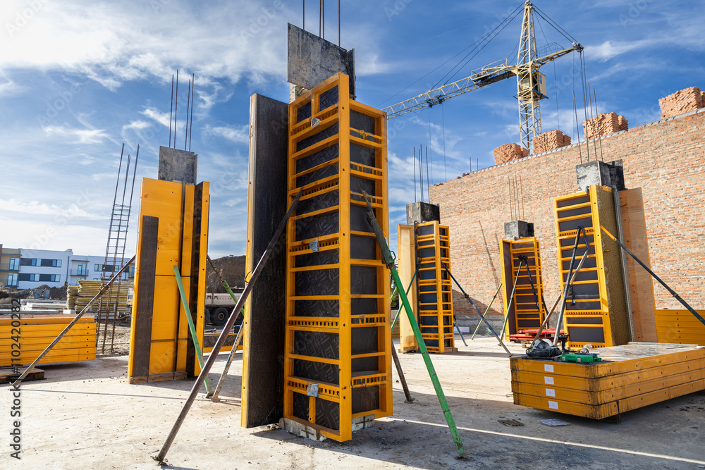 Αυτοκόλλητο Construction site with yellow column formwork and brick wall, ready for concrete
