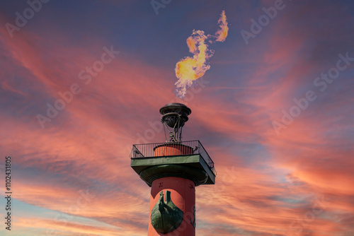 Burning flames on the Rostral columns. Burning rostral columns against the sky in honor of the victory over fascism. Victory Day is May 9th. The fire of the Rostral columns in St. Petersburg, Russia.  photo