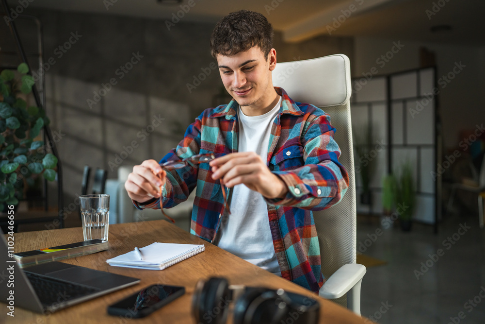 Fototapeta premium man check if the eyeglasses are clean and prepare for study at home